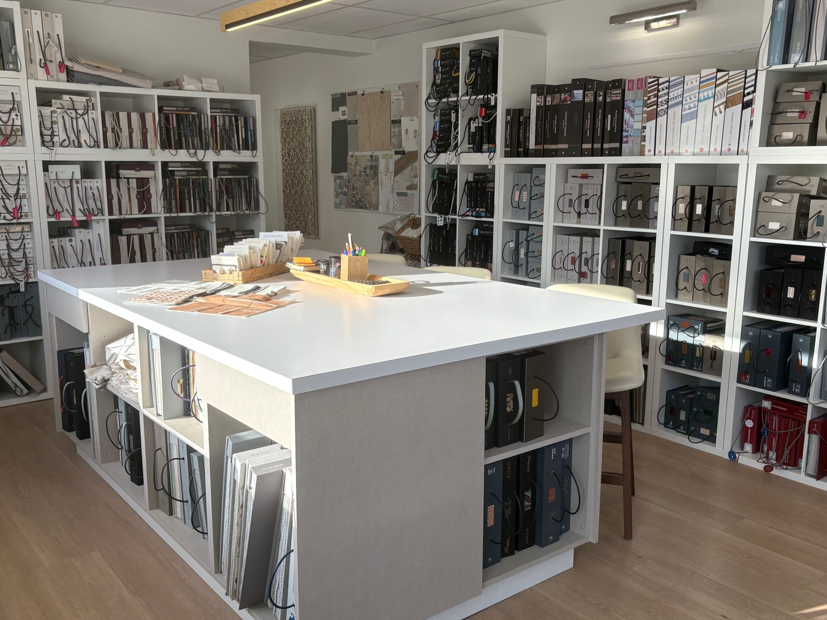 Bright room filled with shelves of vinyl records and a central white table.